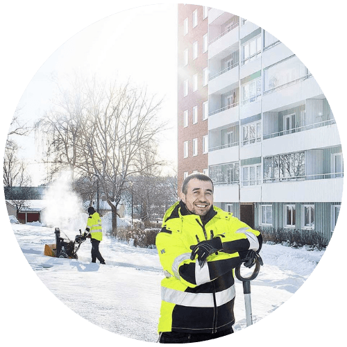 Medarbetare från Renew Service utför snöröjning och halkbekämpning vid ett flerbostadshus
